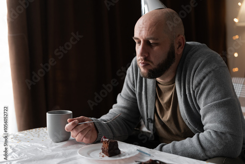 Unhappy birthday guy feeling sad and disappointed celebrate his anniversary alone and eating cake at home. People and celebration