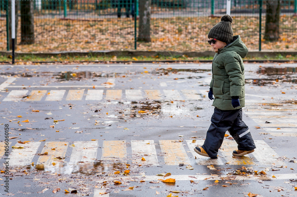 A little boy of 5 years old crosses the street at a pedestrian crossing. Traffic Laws. Be careful-children. A little boy of 5 years old crosses the street at a pedestrian crossing. Traffic Laws. Be careful-children.