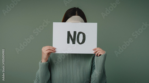 Woman holding sign with the word "No". Ability to refuse and say no. Green background 