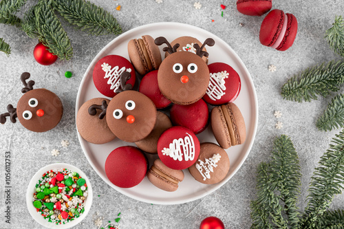 Beautiful Christmas chocolate and raspberry macarons on a plate on a concrete background. Festive dessert. Top view, copy space. photo