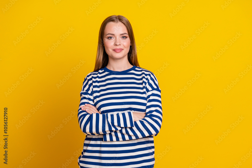 Photo of adorable cute woman wear striped stylish clothes arms folded isolated on yellow color background Photo of adorable cute woman wear striped stylish clothes arms folded isolated on yellow color background
