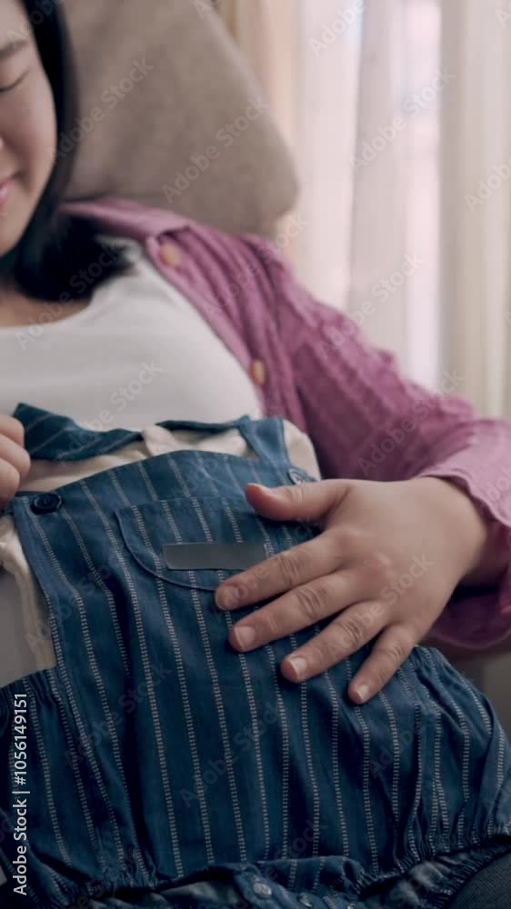 Pregnant woman feeling happy at home while taking care of her child. The young expecting mother holding baby in pregnant belly. Maternity prenatal care and woman pregnancy concept.