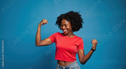 HDR photo of cinematic photo breathtaking Portrait of sexy gorgeous young african-American woman raise fists wear RED TEE SHIRT isolated on blue color background