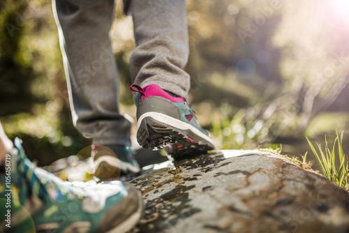 Two people hiking on wet rock near a river