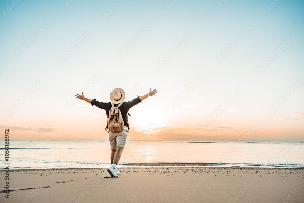 Happy man with backpack standing with arms up at the beach - Delightful tourist enjoying summer vacation by the seaside - Traveling life style and well being concept Happy man with backpack standing with arms up at the beach - Delightful tourist enjoying summer vacation by the seaside - Traveling life style and well being concept