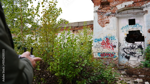 Fototapeta Naklejka Na Ścianę i Meble -  A drone in the sky next to a ruined, abandoned building.