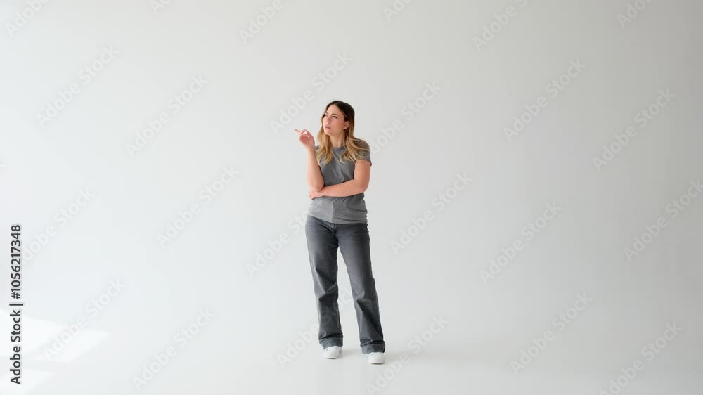 Pensive Caucasian young adult woman thinking and having brilliant idea, pointing finger up on white background. Concept of an eureka. Pensive Caucasian young adult woman thinking and having brilliant idea, pointing finger up on white background. Concept of an eureka.