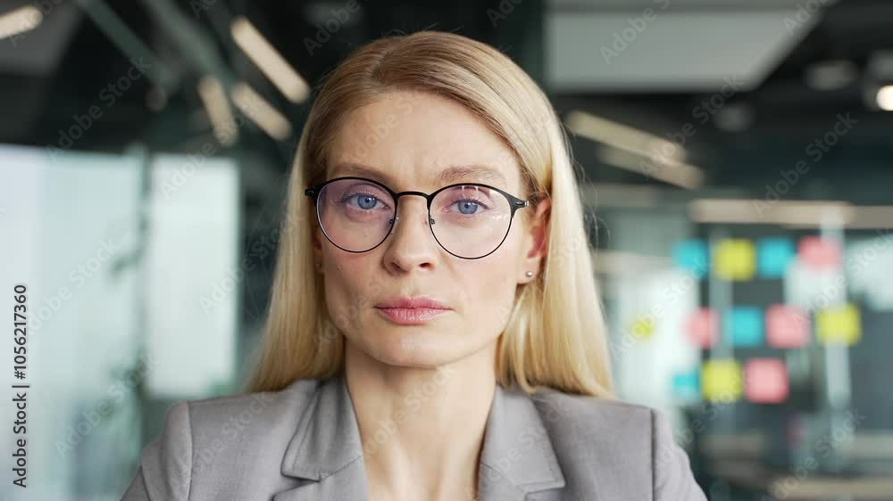 Webcam view. Focused female manager watching video call conference or training looking at camera sitting in business office. Woman is studying online, listening remotely to course or seminar. Close up