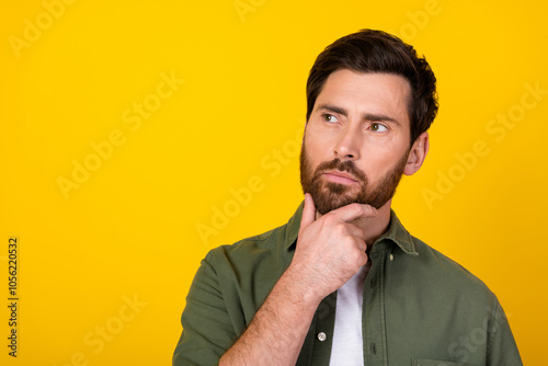 Portrait of nice young man look empty space wear khaki shirt isolated on yellow color background