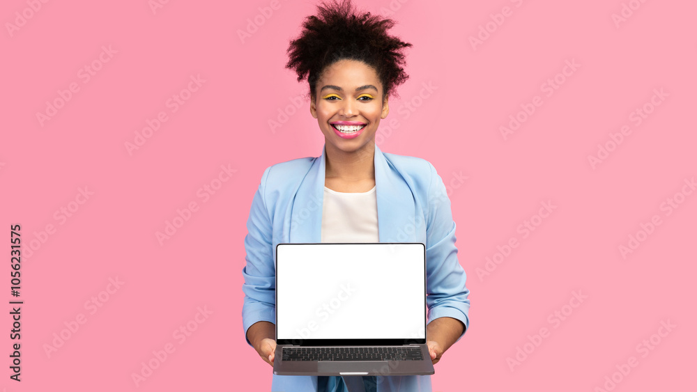 Useful Website. Cheerful afro girl holding laptop computer, showing blank screen over pink studio wall, mock up Useful Website. Cheerful afro girl holding laptop computer, showing blank screen over pink studio wall, mock up