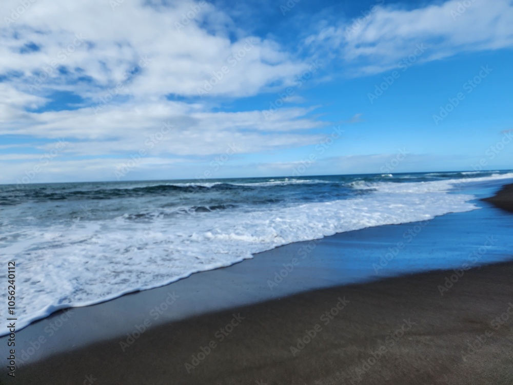 waves on the beach and a bigger foam in the coast with clouds in the sky waves on the beach and a bigger foam in the coast with clouds in the sky