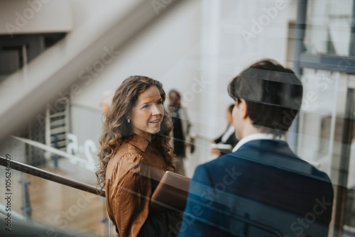 Rear view of young businessman discussing with businesswoman seen through glass