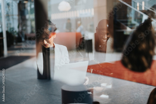 Smiling bald businessman working with female colleague seen through glass photo