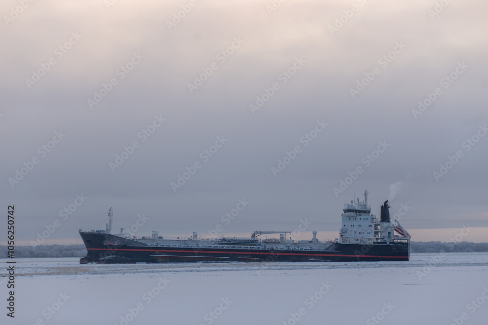 A large ship is peacefully floating on the water on a cloudy day, making for an interesting sight against the overcast sky A large ship is peacefully floating on the water on a cloudy day, making for an interesting sight against the overcast sky