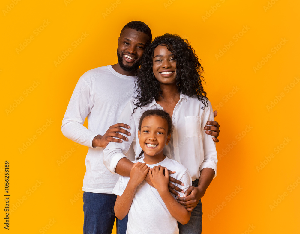 Happy Family Of Three Hugging Posing Over Yellow Background In Studio Happy Family Of Three Hugging Posing Over Yellow Background In Studio