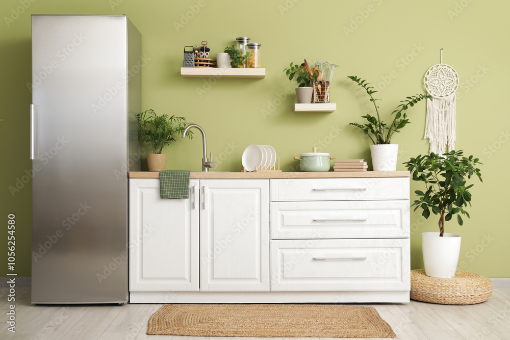 Fototapeta premium Interior of kitchen with silver fridge, counters and shelves