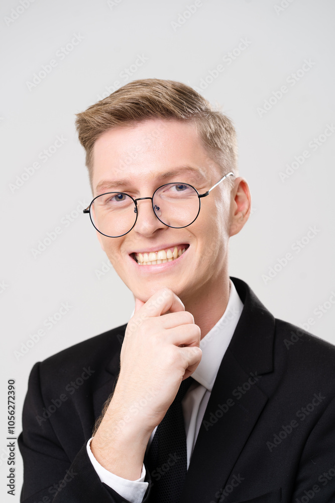 Man wearing glasses and a suit is smiling. He is wearing a tie and a black jacket Man wearing glasses and a suit is smiling. He is wearing a tie and a black jacket