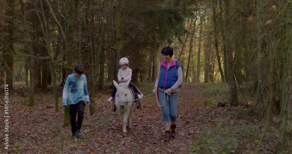 Three children stroll through a serene forest, one wearing a unicorn costume, capturing playful innocence. Three children stroll through a serene forest, one wearing a unicorn costume, capturing playful innocence.