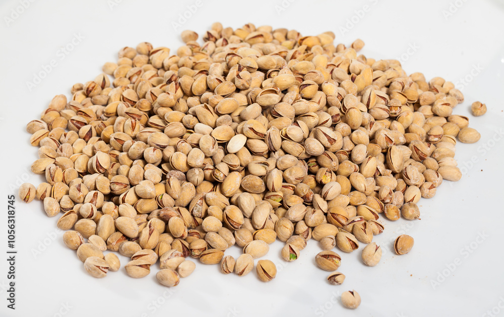 Fototapeta premium Heap of pistachios scattered on white surface