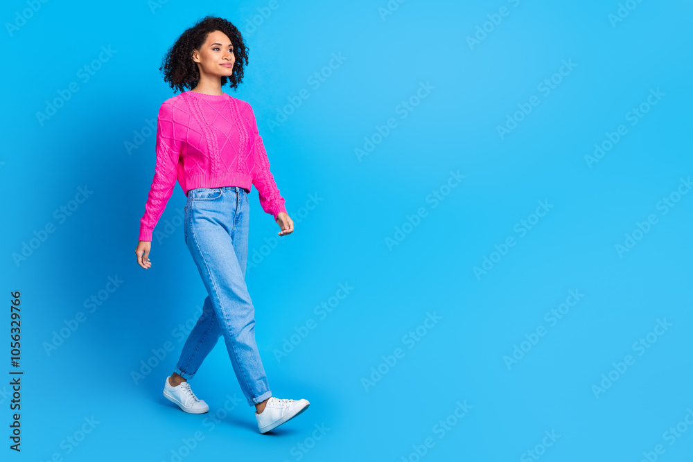 Full body photo of attractive young woman walk empty space bags dressed stylish pink clothes isolated on blue color background Full body photo of attractive young woman walk empty space bags dressed stylish pink clothes isolated on blue color background