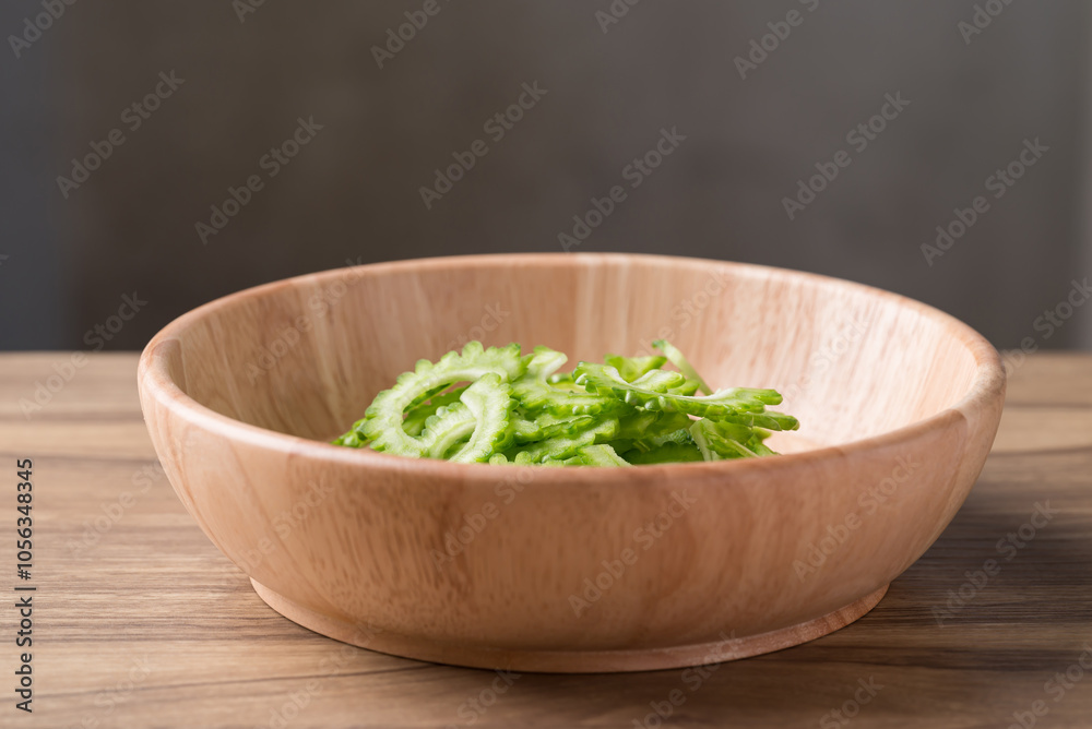 Sliced bitter gourd in bowl on wooden table, Food ingredient Sliced bitter gourd in bowl on wooden table, Food ingredient