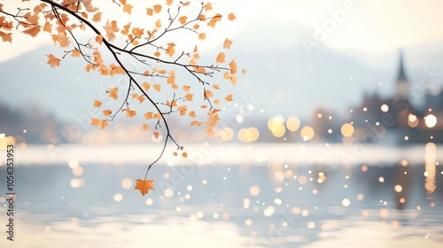 A single branch with autumn leaves hangs over a still lake, reflecting the warm glow of lights from a village in the distance.