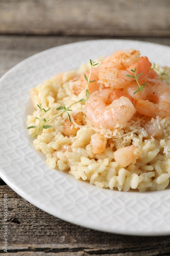 Delicious risotto with shrimps and cheese on wooden table, closeup Delicious risotto with shrimps and cheese on wooden table, closeup