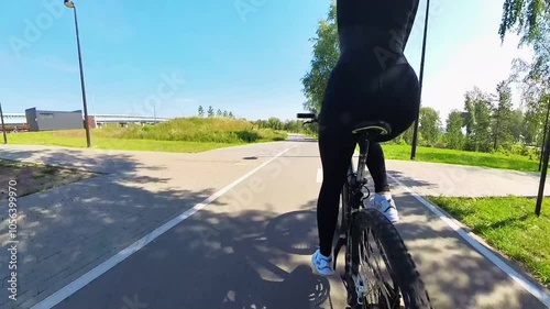 Rear view of a Caucasian woman riding a bicycle. photo