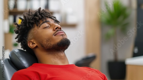 A young man in a red shirt reclines comfortably in a serene environment, capturing a tranquil moment as he unwinds and meditates quietly. photo