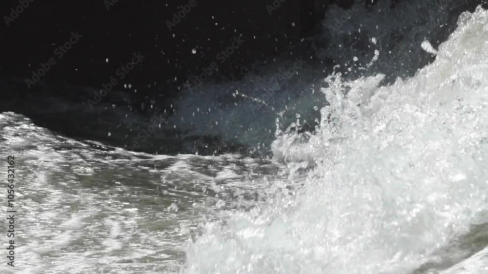 Slow motion closeup of a large wave of whitewater crashing in a concrete channel