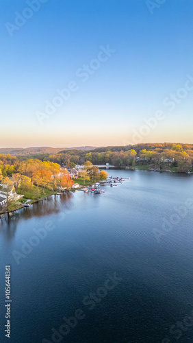 Tranquil sunset over a serene lake, capturing the peaceful reflections of fading sunlight on calm waters with silhouetted trees on the shoreline.