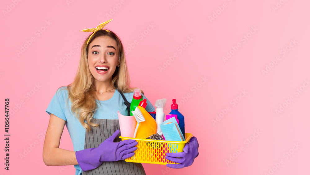 Start of house cleaning. Happy housewife with basket with cleaning supplies isolated on pink background, studio shot Start of house cleaning. Happy housewife with basket with cleaning supplies isolated on pink background, studio shot