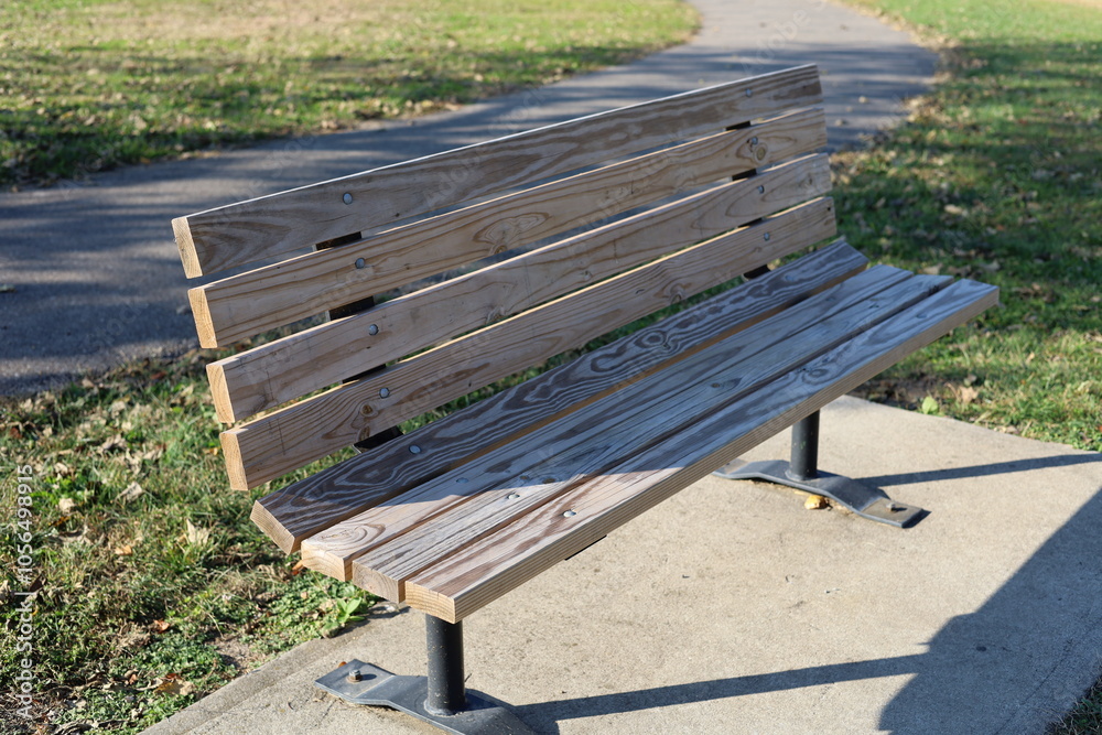Solitary wooden park bench sitting alone in public park Solitary wooden park bench sitting alone in public park