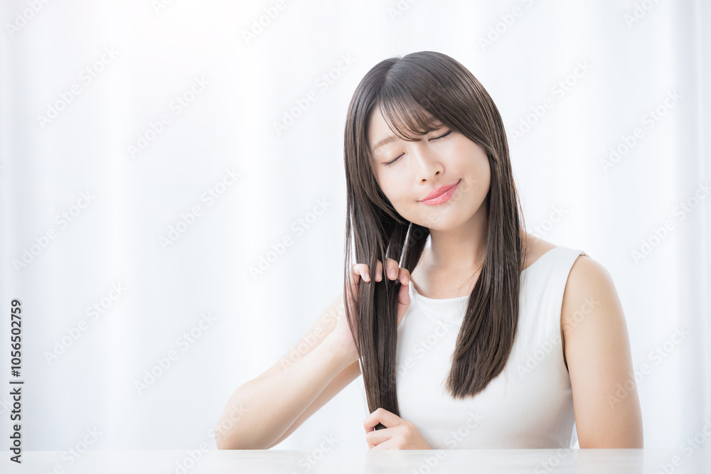 Close-up of a young woman taking care of her hair, close-up of her eyes blue close-up Angel ring in long hair Close-up of a young woman taking care of her hair, close-up of her eyes blue close-up Angel ring in long hair