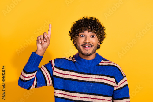 Photo portrait of attractive young man point up eureka empty space dressed stylish blue striped clothes isolated on yellow color background photo