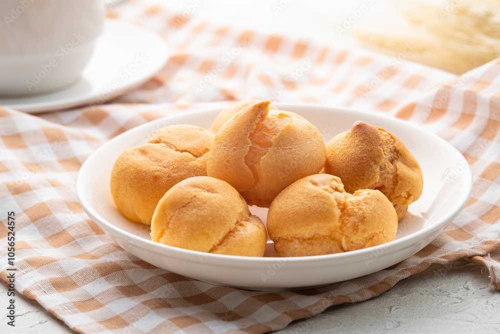Close up choux pastry or cream puffs or eclair with Vanilla custard fillings in white plate Close up choux pastry or cream puffs or eclair with Vanilla custard fillings in white plate