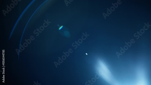 Blue lens flares overlay fading out into black background. Slow motion.