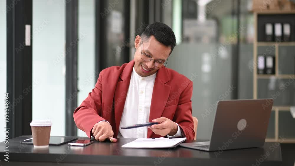 Young man using laptop and tablet while sitting at her working place. Concentrated at work. Young man using laptop and tablet while sitting at her working place. Concentrated at work.