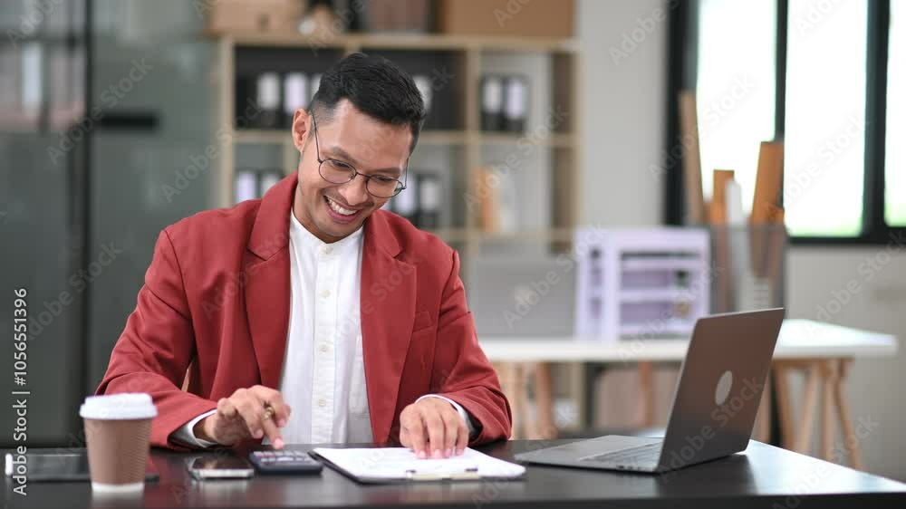 Young man using laptop and tablet while sitting at her working place. Concentrated at work. Young man using laptop and tablet while sitting at her working place. Concentrated at work.