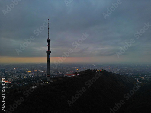 Koktobe TV tower on the hill after sunset. View of the city. Cloud cover. Autumn. photo