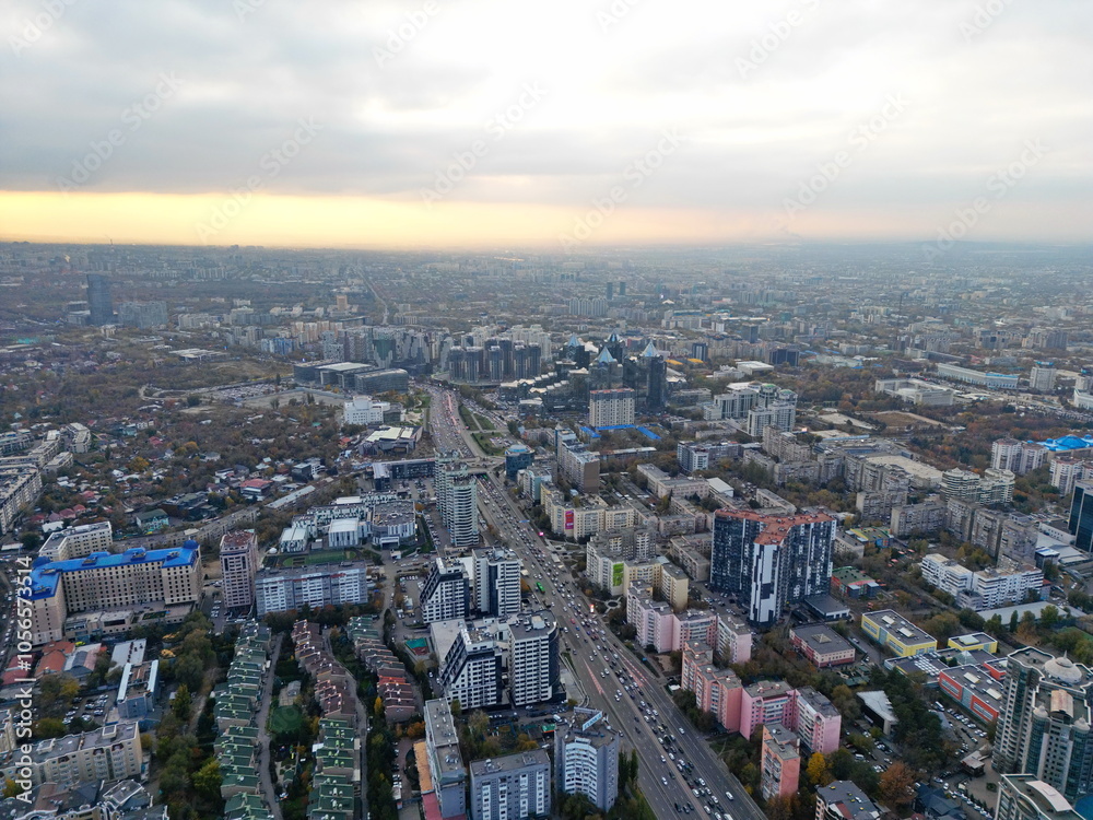 Obraz premium View of the city, with different buildings and streets. Sunset time. Autumn. The view from the drone.