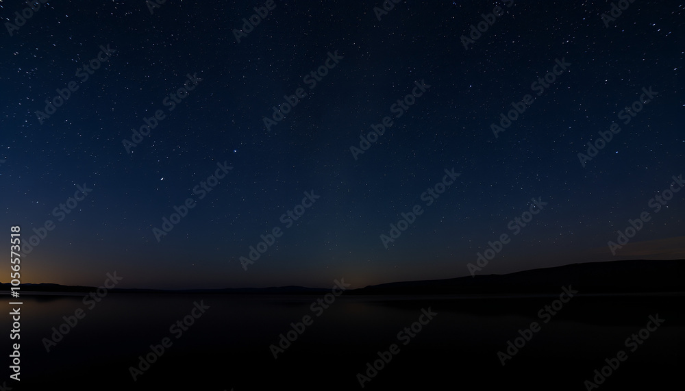 Starry night sky over a calm lake, with stars reflecting on the water surface, creating a tranquil atmosphere.