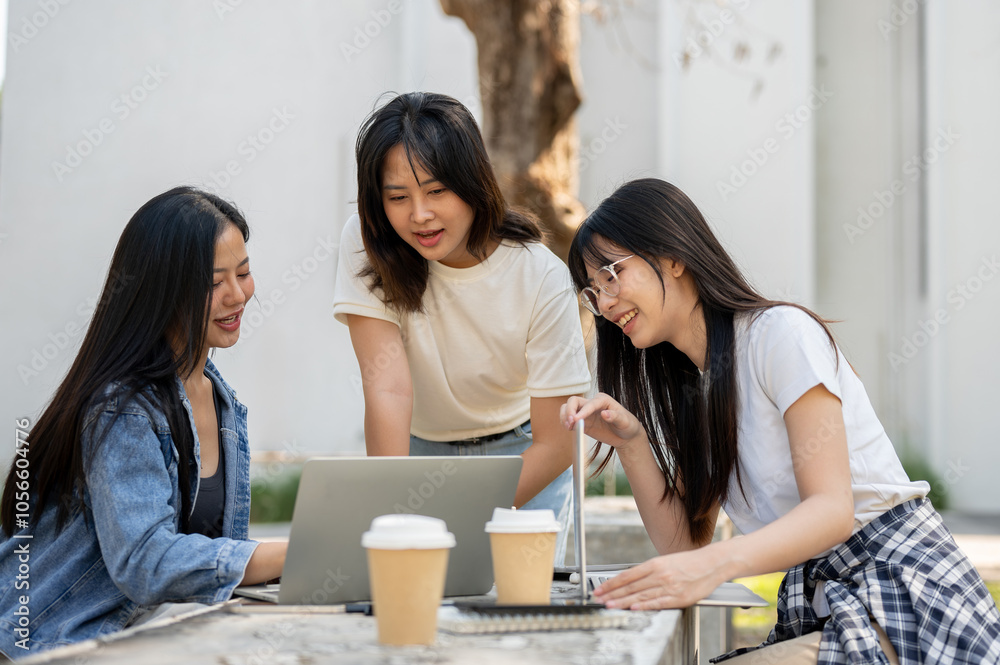 A group of young Asian female college students is focused on discussing a project. A group of young Asian female college students is focused on discussing a project.