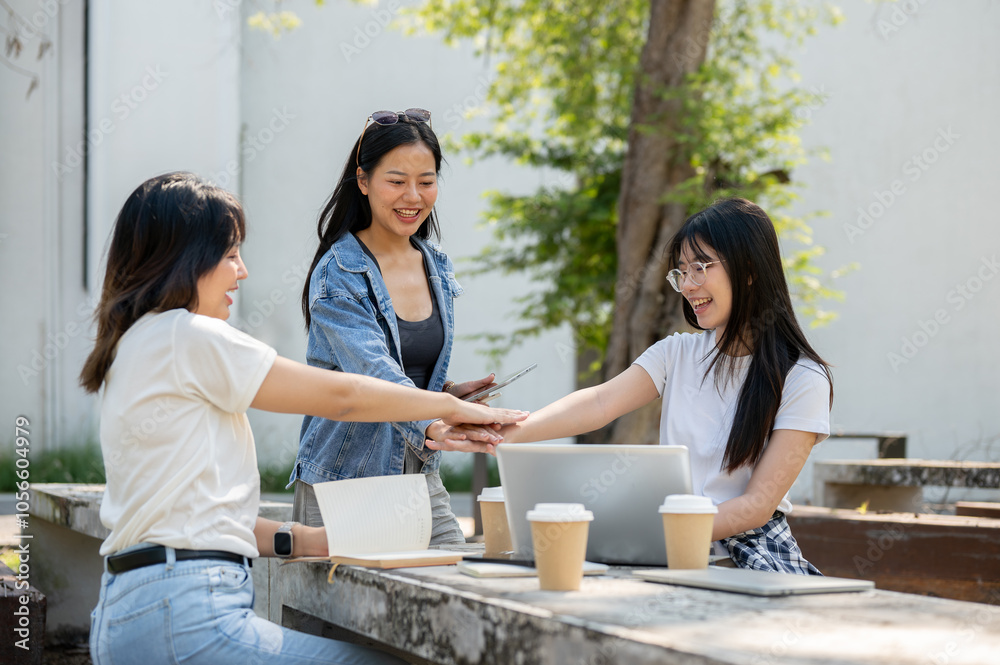 A group of cheerful young Asian female college students is putting their hands together. A group of cheerful young Asian female college students is putting their hands together.