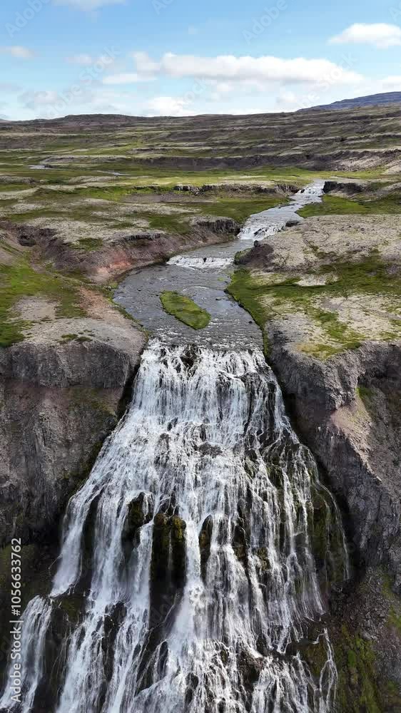 Aerial view of the breathtaking Hrisvaosfoss waterfall in Iceland, vertical video pullback. Aerial view of the breathtaking Hrisvaosfoss waterfall in Iceland, vertical video pullback.