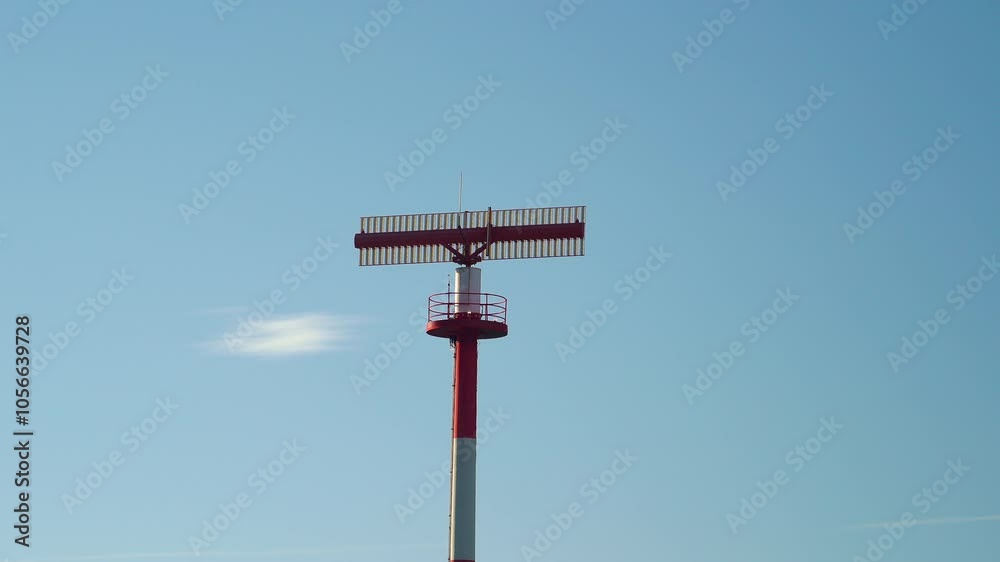 Radar system monitoring air traffic from a tall tower under a clear blue sky during daylight at an airport Radar system monitoring air traffic from a tall tower under a clear blue sky during daylight at an airport