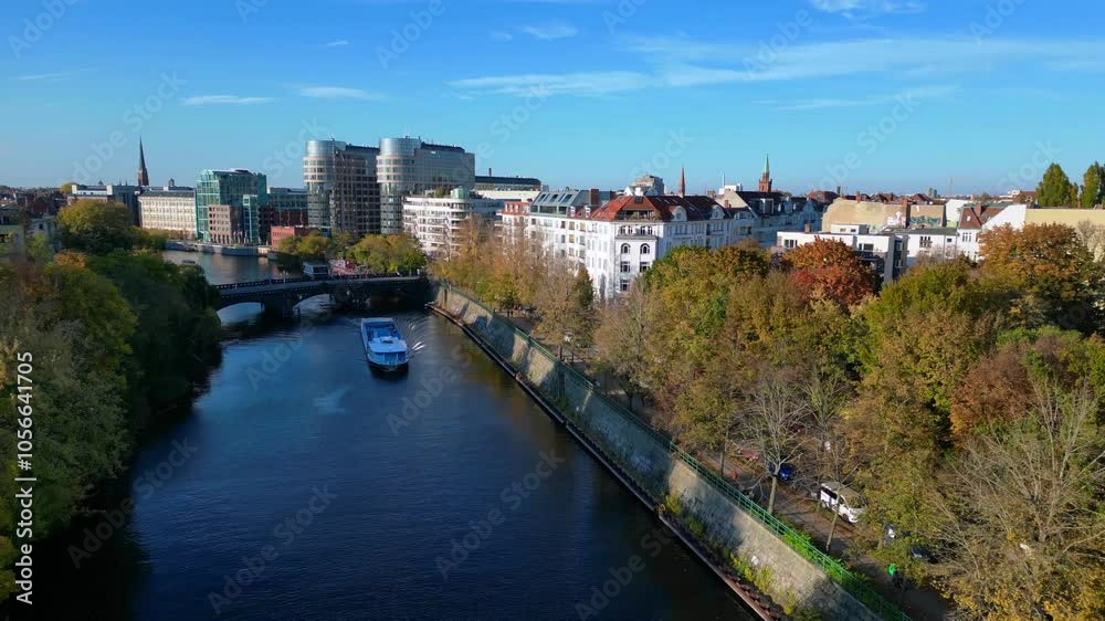 Picturesque cityscape of berlin featuring the landwehr canal, a bridge, buildings, and colorful autumn trees on a sunny day. Wonderful aerial view flight fly reverse drone Picturesque cityscape of berlin featuring the landwehr canal, a bridge, buildings, and colorful autumn trees on a sunny day. Wonderful aerial view flight fly reverse drone