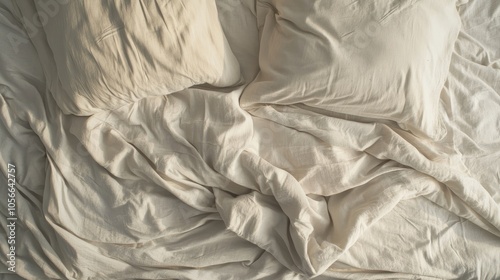 Aerial view of a disheveled bed featuring wrinkled bedding