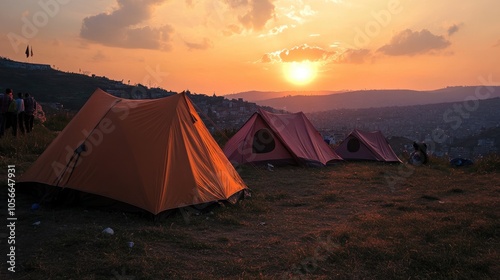 Tents set up on a hillside during sunset