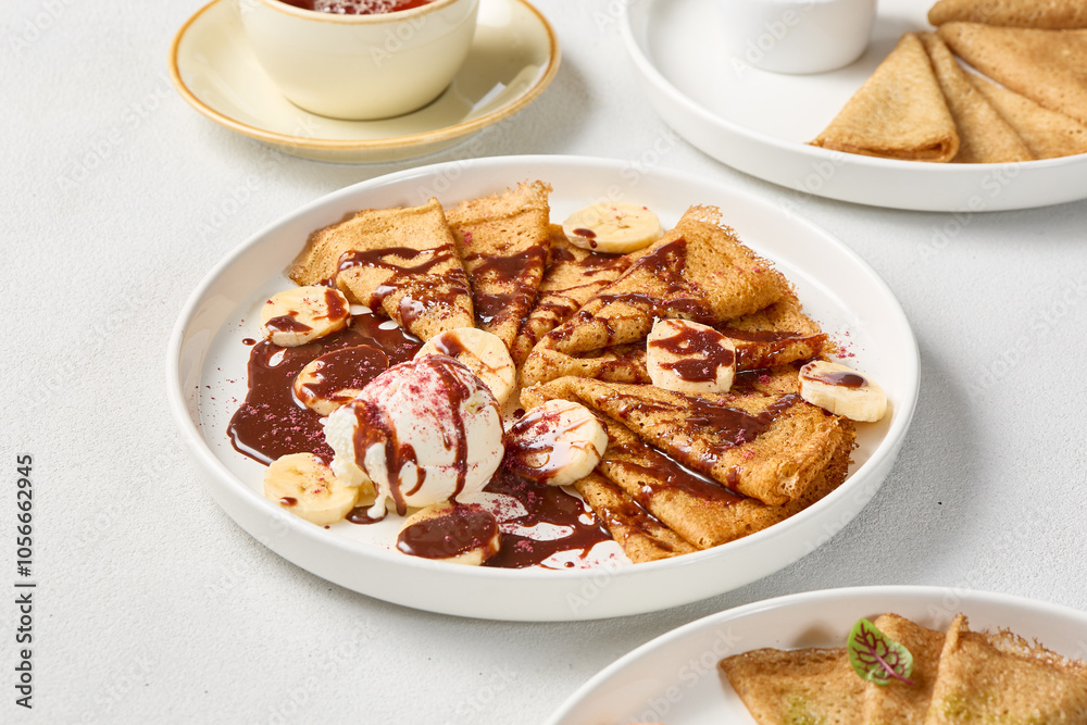 Delicious Pancakes with Banana, Chocolate Spread, and Ice Cream on White Plate Delicious Pancakes with Banana, Chocolate Spread, and Ice Cream on White Plate